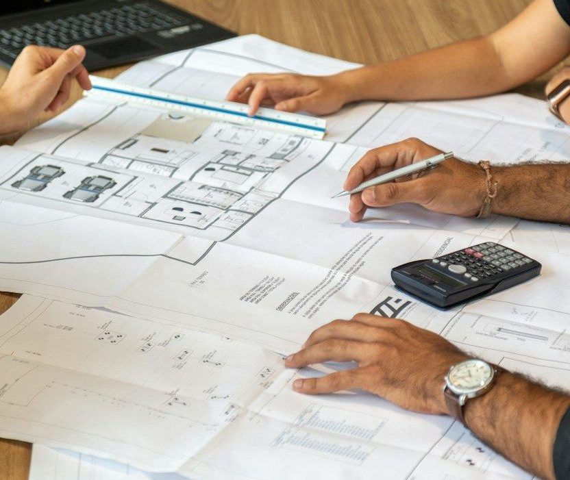 people reviewing architectural blueprints on desk